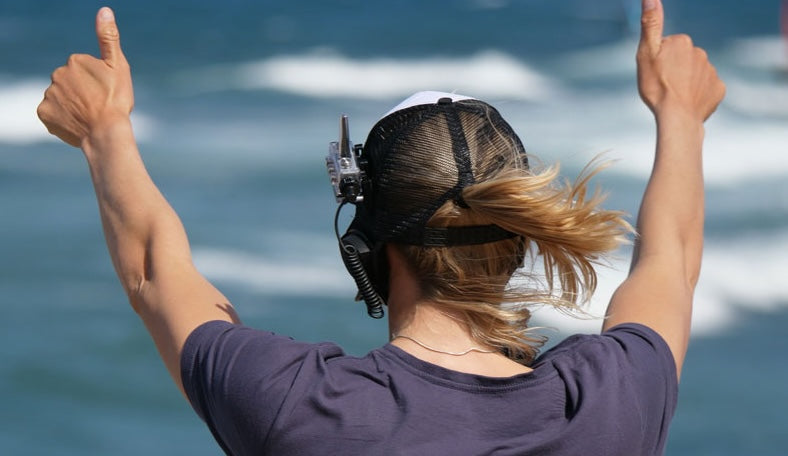 Kitesurfer signalling to the beach with a raised arm before launching the kite