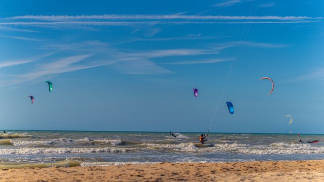 kitesurfers on the water in front of a blue sky
