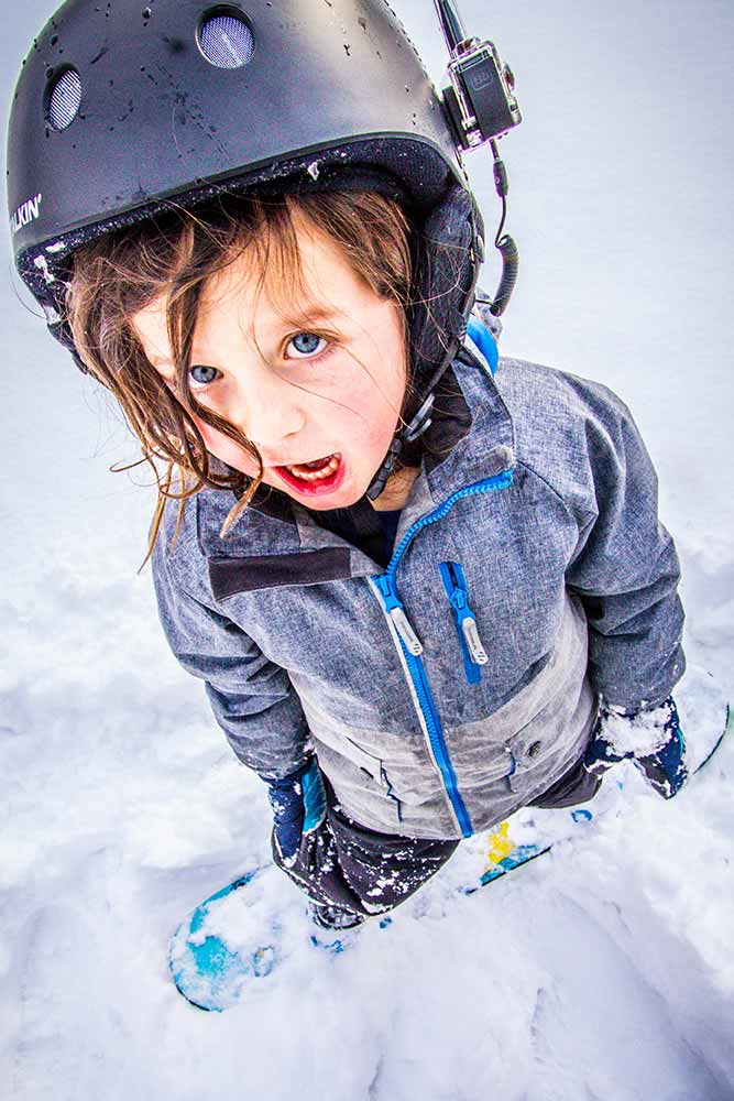 Child wearing helmet with BbTalkin intercom system for winter sports communication