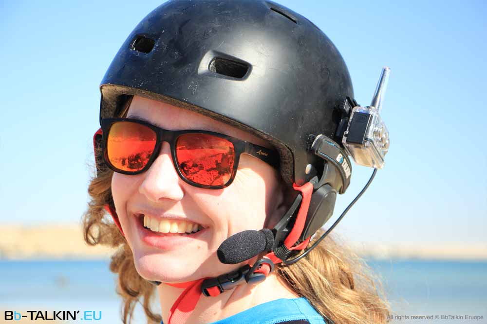 Female athlete wearing BbTalkin helmet headset during watersport activity with clear blue water background
