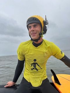 Ben Neumann sitting on his board, using BbTalkin for real-time surf guidance