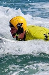 Ben Neumann adaptive surfer wearing BbTalkin headset on water