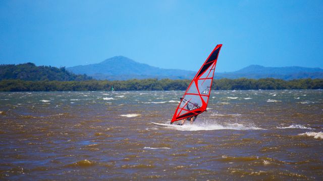 Windsurfing instructor using BbTalkin waterproof intercom in high wind