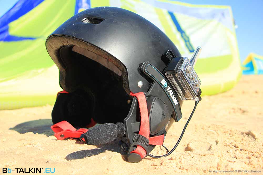 BbTalkin-Helm-Headset, montiert auf einem schwarzen Helm, mit Seitenansicht und Strand-Wassersport-Setup