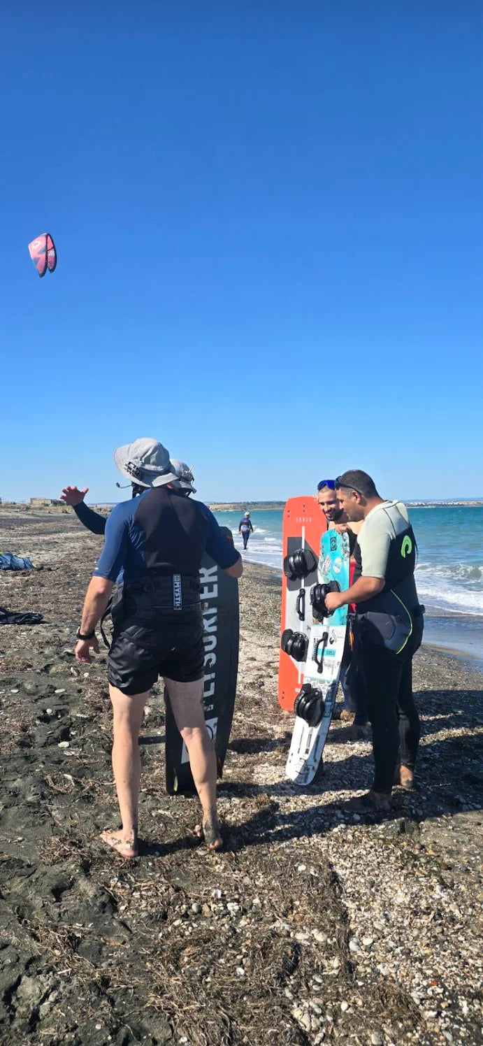 Instrutor de kitesurf a treinar alunos na praia usando o intercomunicador Bluetooth à prova de água BbTalkin